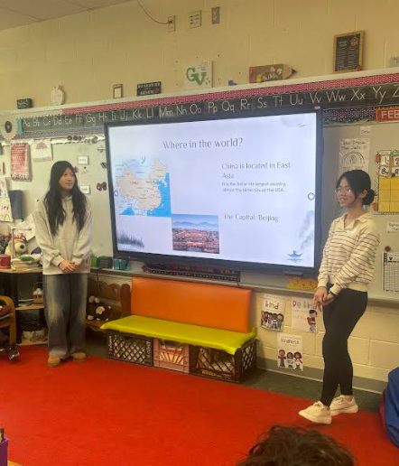 two girls standing on different sides of a board presenting