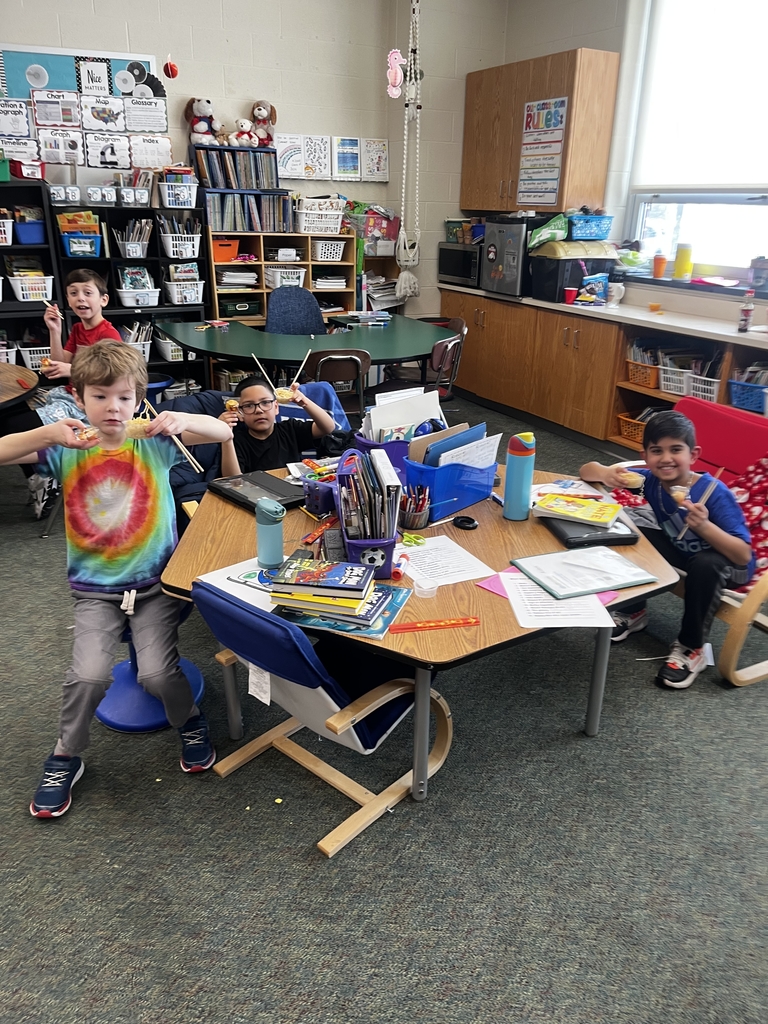 kids sitting at a table with chopsticks, noodles and fortune cookies 