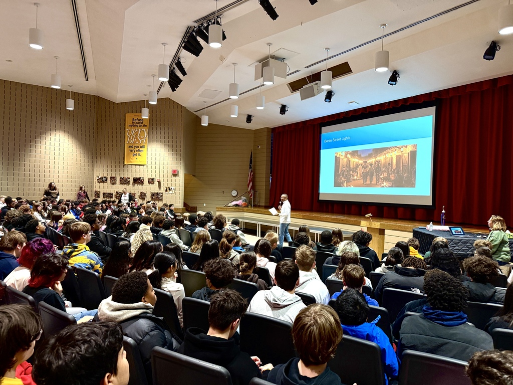 man giving presentation to auditorium of students