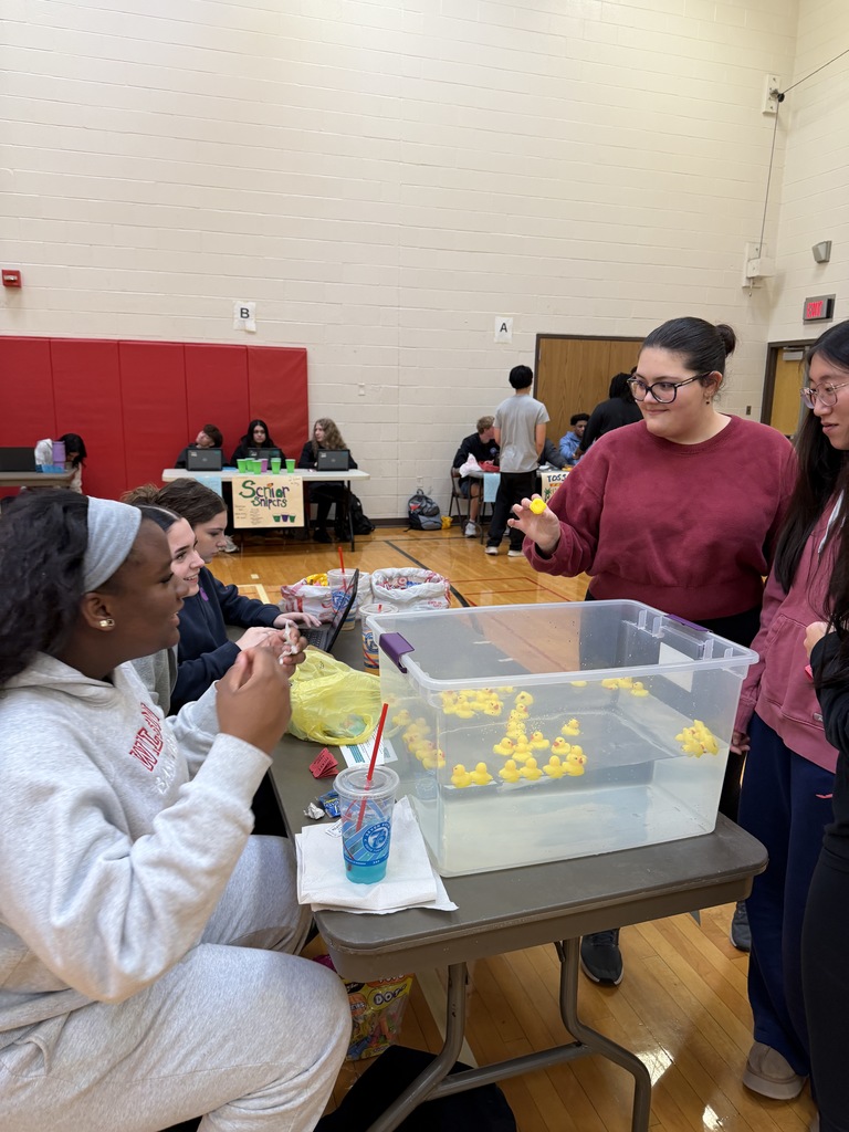 students picking ducks out of bin of water