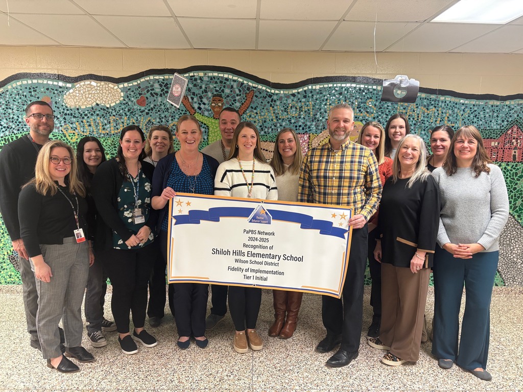 picture of staff members holding a banner