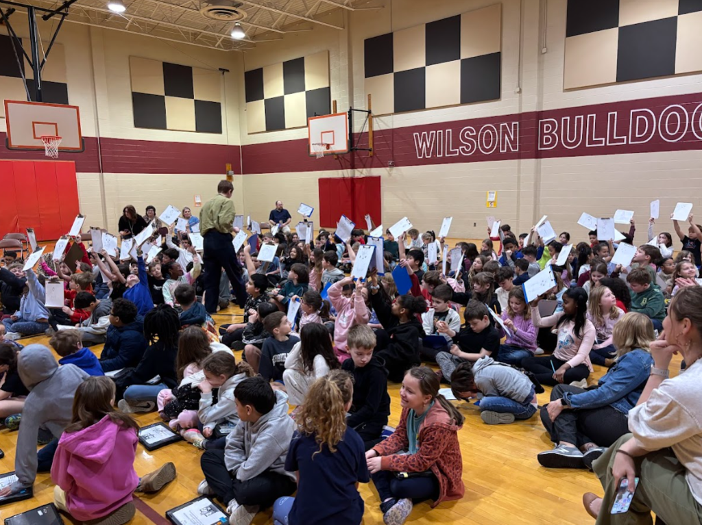 students holding papers in the air
