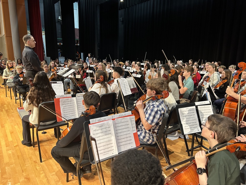 students on stage with conductor