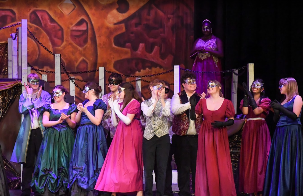 cast smiling and clapping hands all in masks