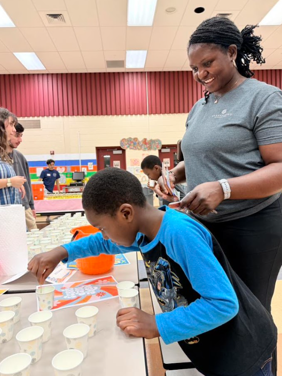 student with parent doing experiment in dixie cup