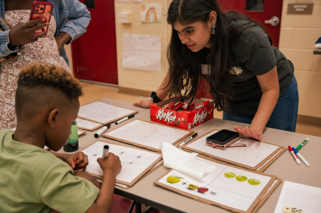 student working with adult writing on dry erase board