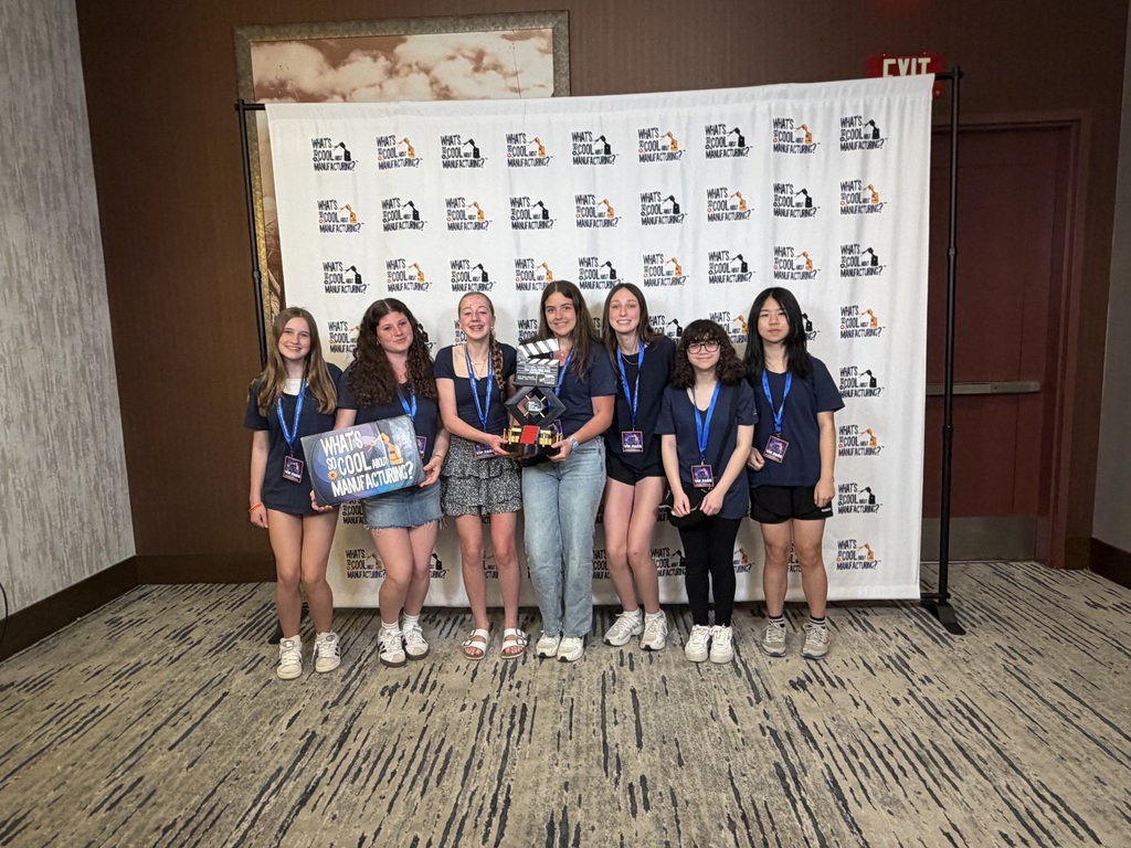 students with trophy infront of backdrop