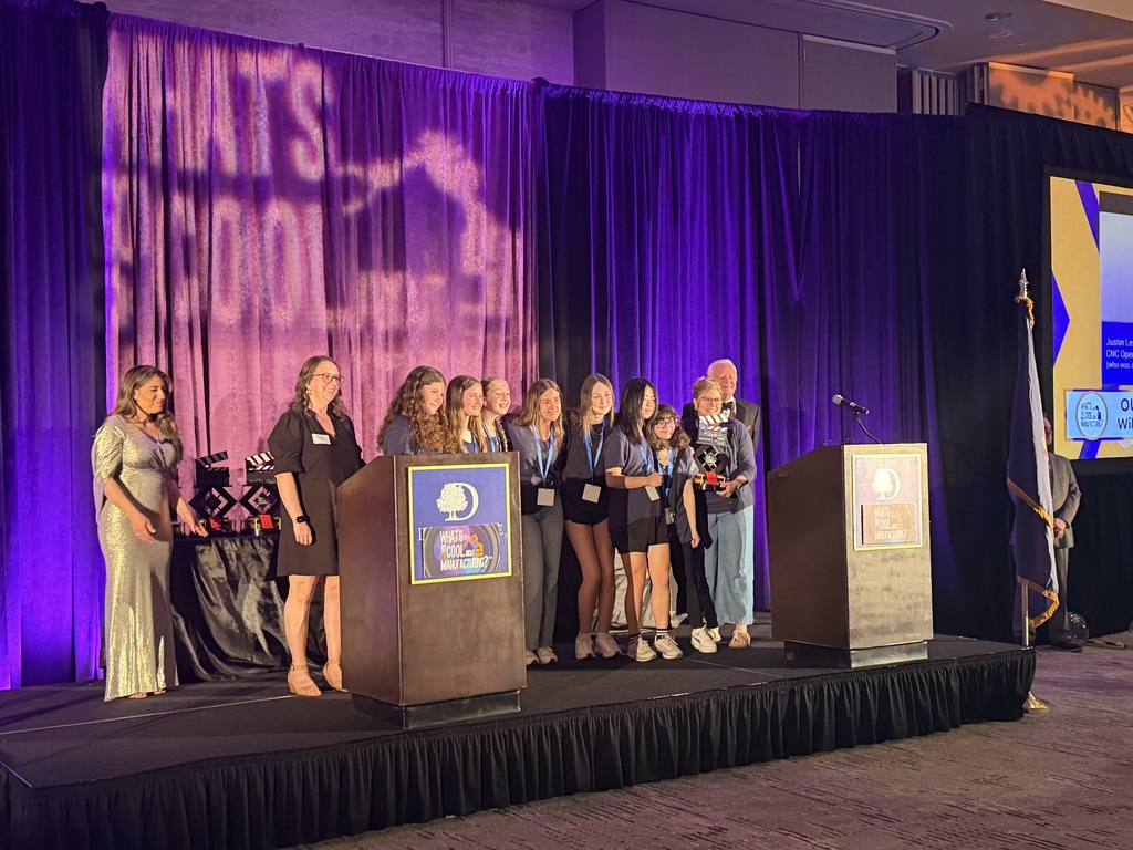 students on stage accpeting trophy