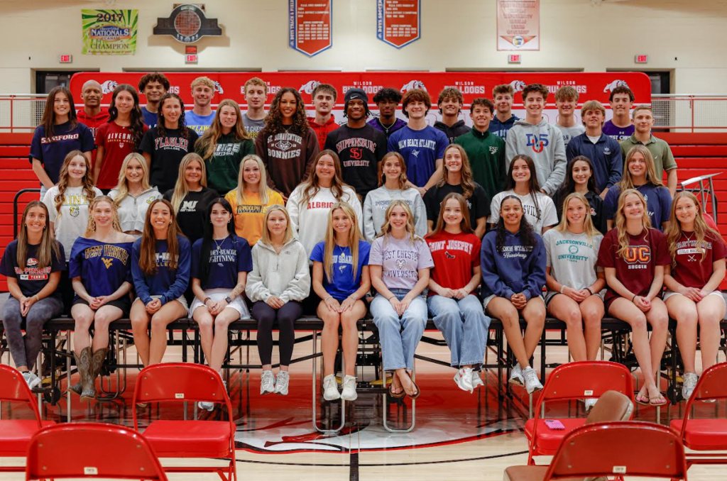 Group of students on stage wearing their college shirt