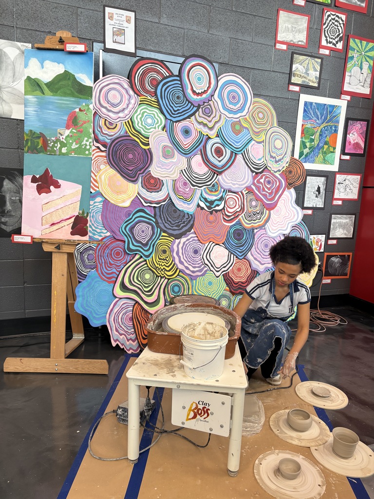 student with pottery wheel and pieces created