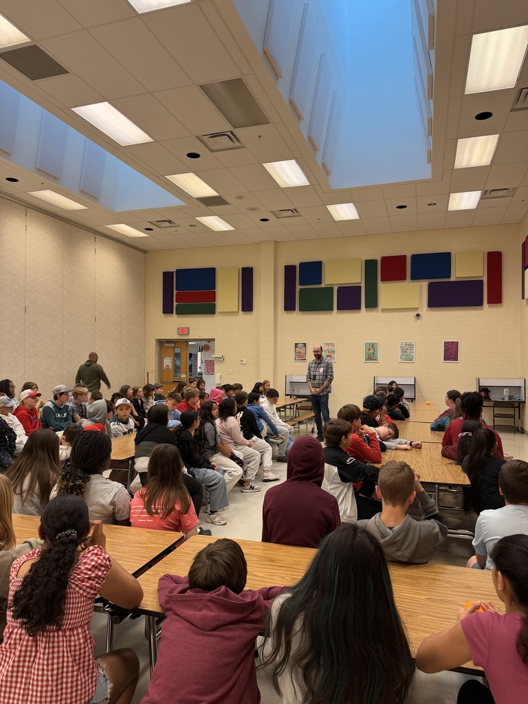 presenter speaking to classes in cafeteria