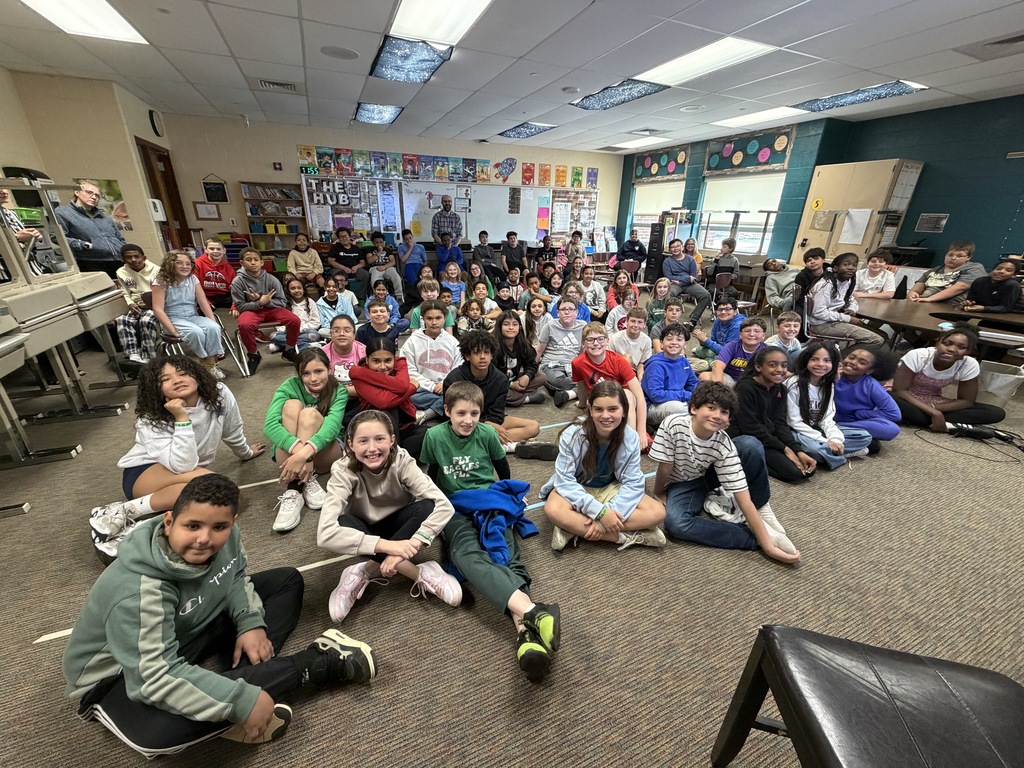 students in a classroom smiling at camera 