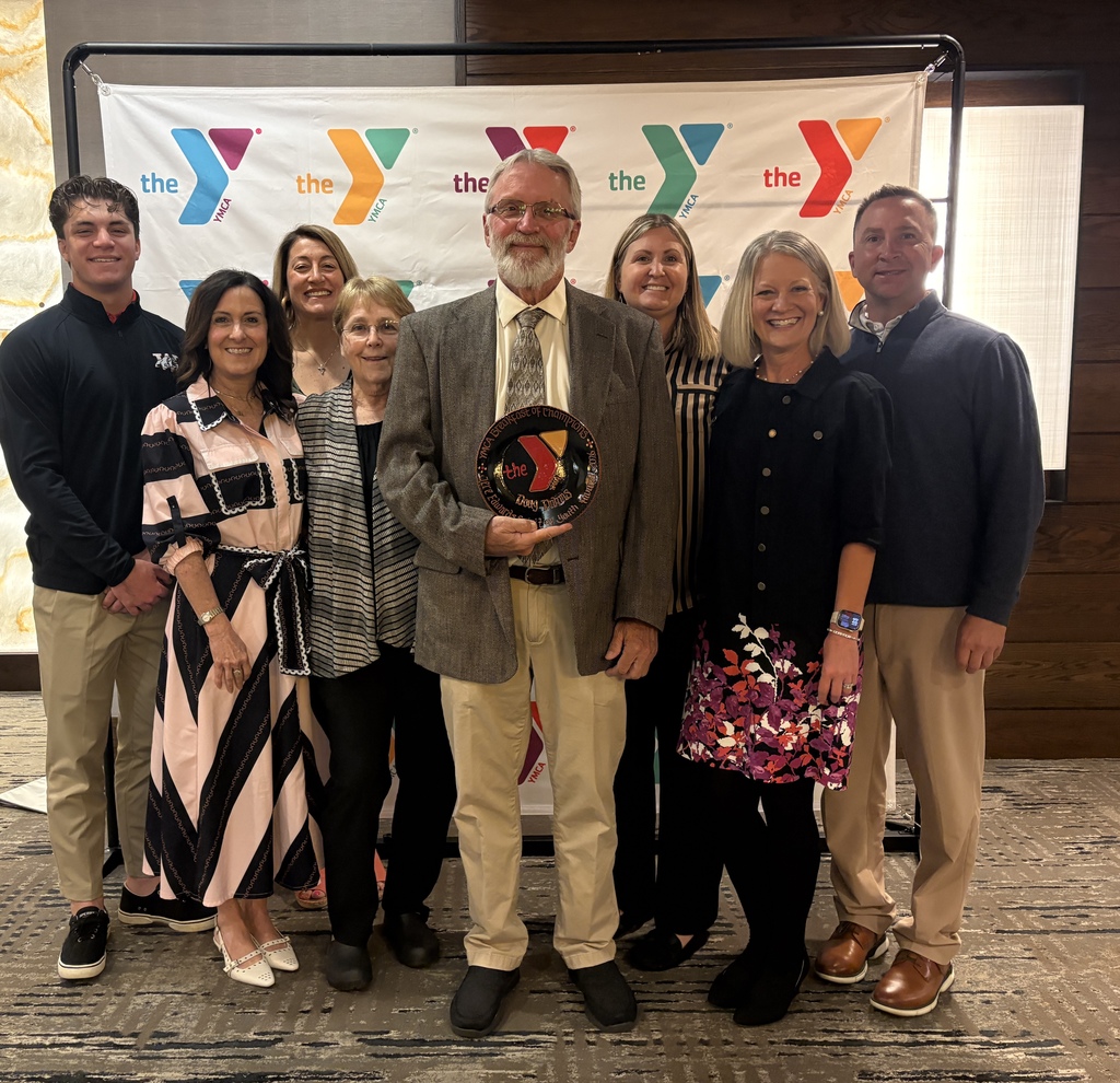 group of people behind doug dahms in front of The Y backdrop