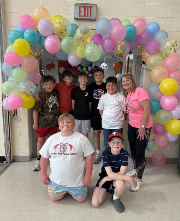 STudents and teacher under balloon arch