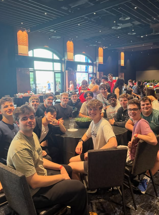 large group of boys inside sitting around a round table