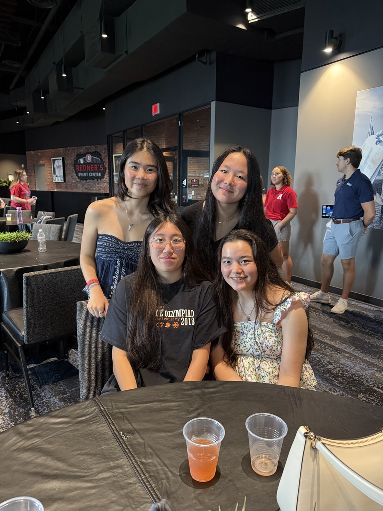 students smiling sitting at round table