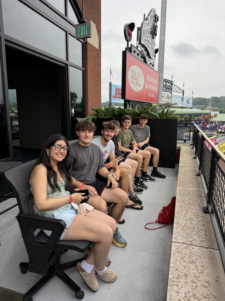 students sitting watching the baseball game