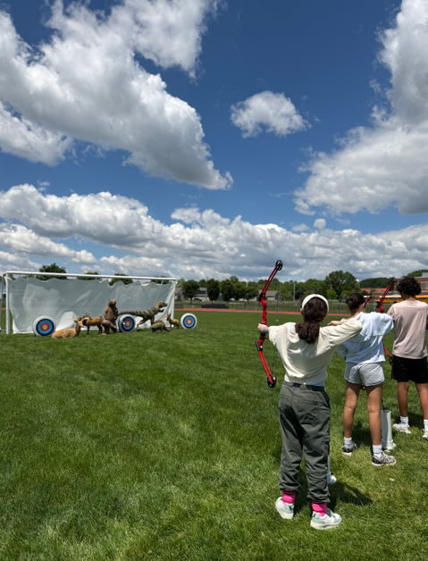 students shooting bow and arrow