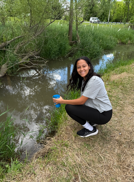 Girl by the stream getting ready to release a fish