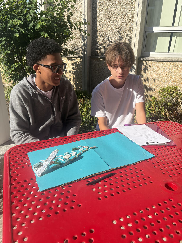 students working together on project at picnic table