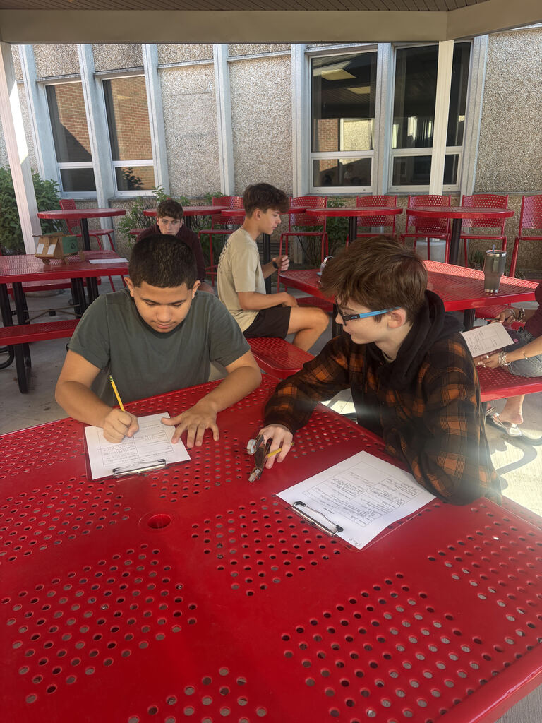 students working on writing on clip board