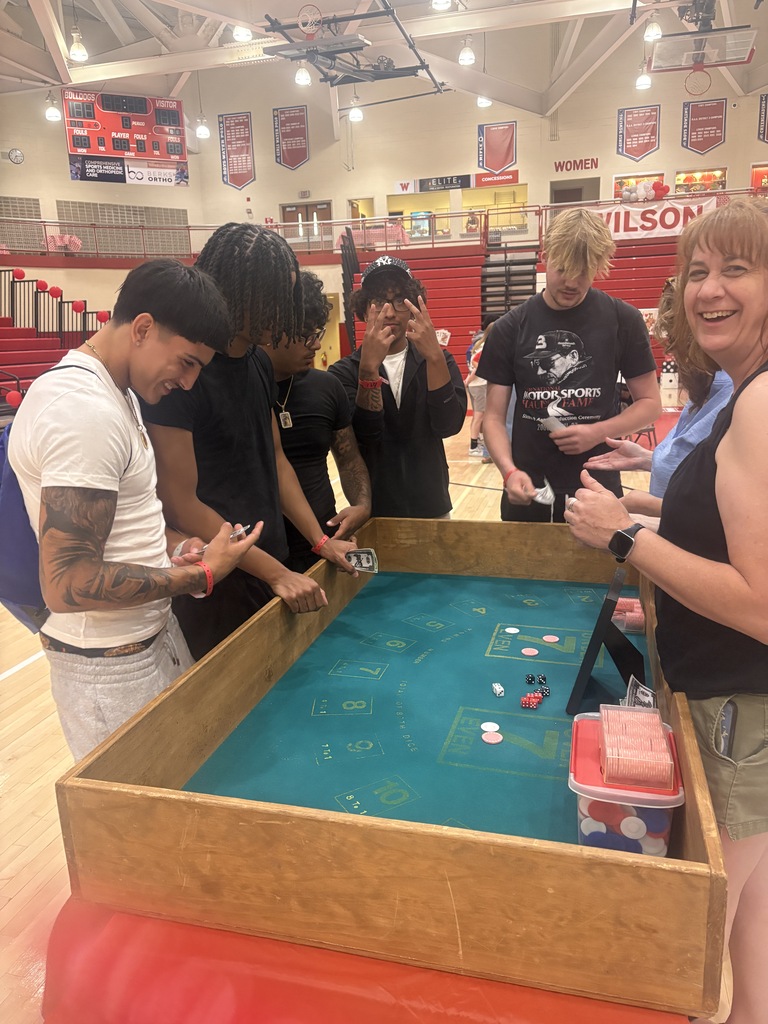 students playing casino game standing around the table