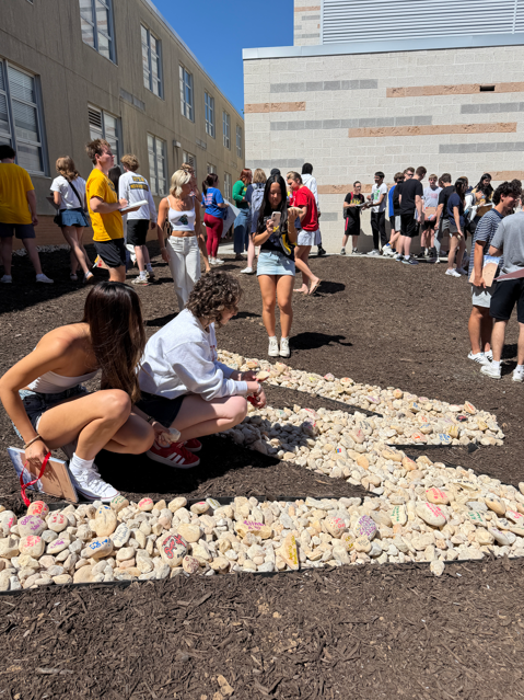 students placing rocks outside