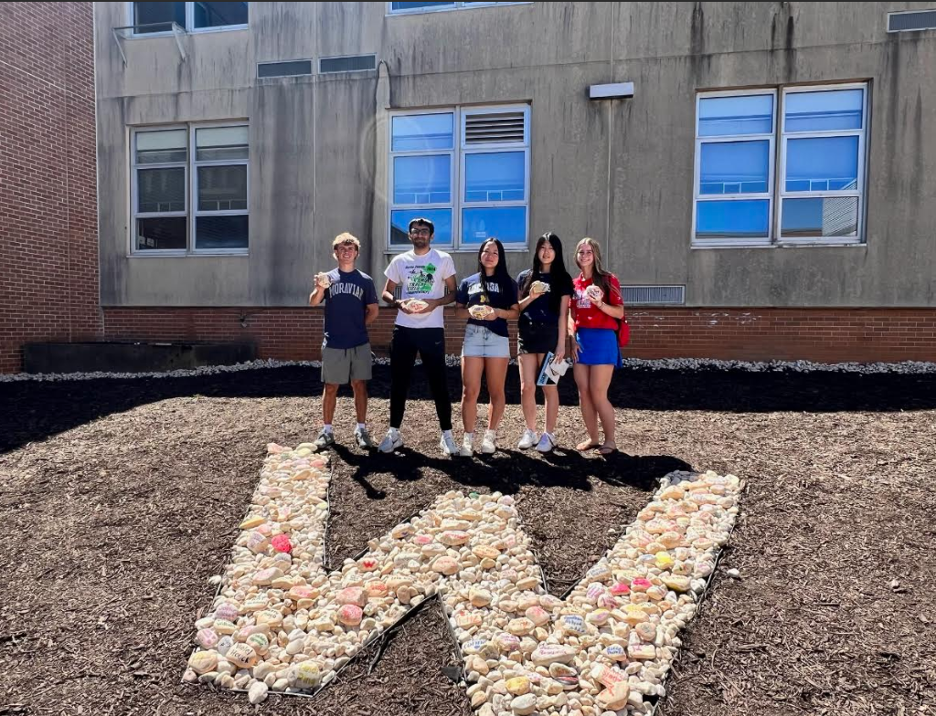 class officers standing behind rock