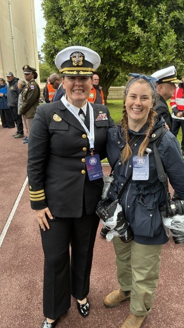 commander standing smiling with someone with cameras