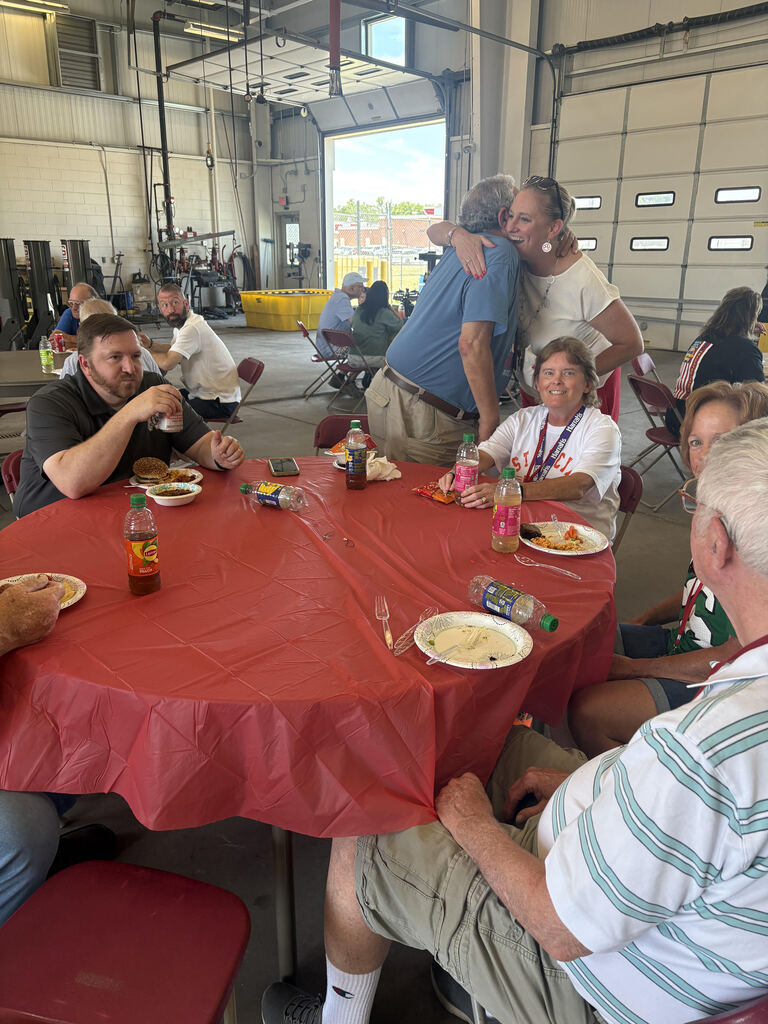 people sitting around red table hugging