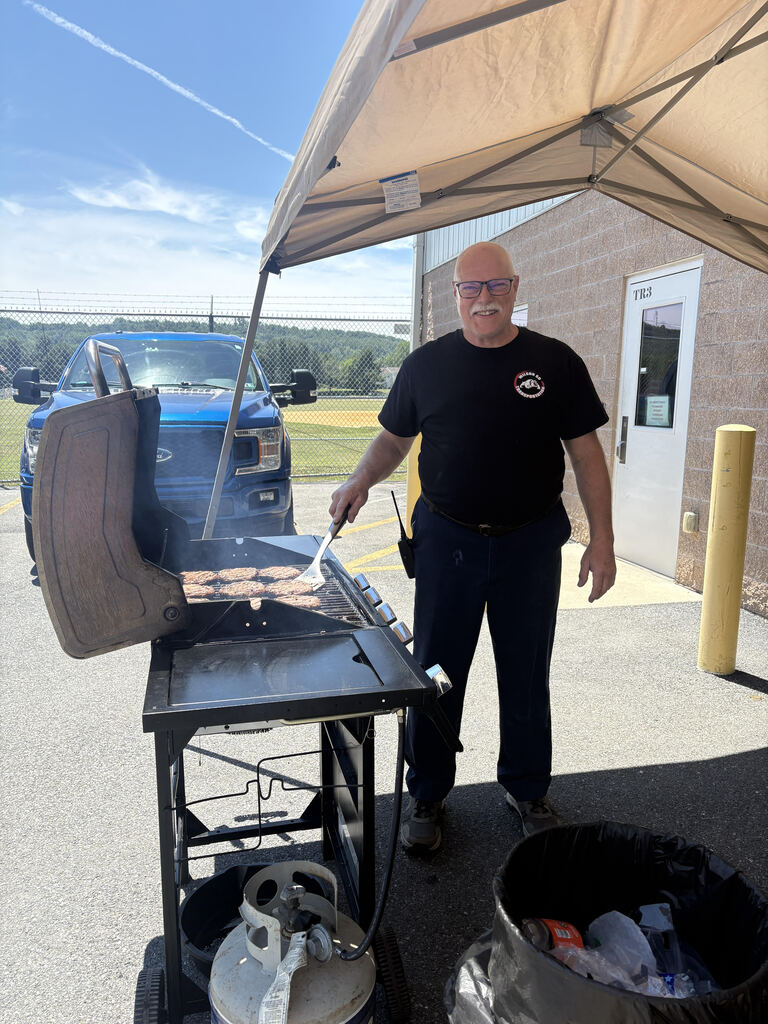 man cooking burgers on a grill