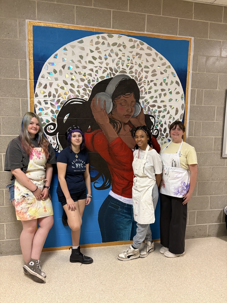 art students standing in front of mural
