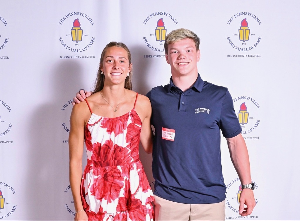 students smiling at camera in front of backdrop