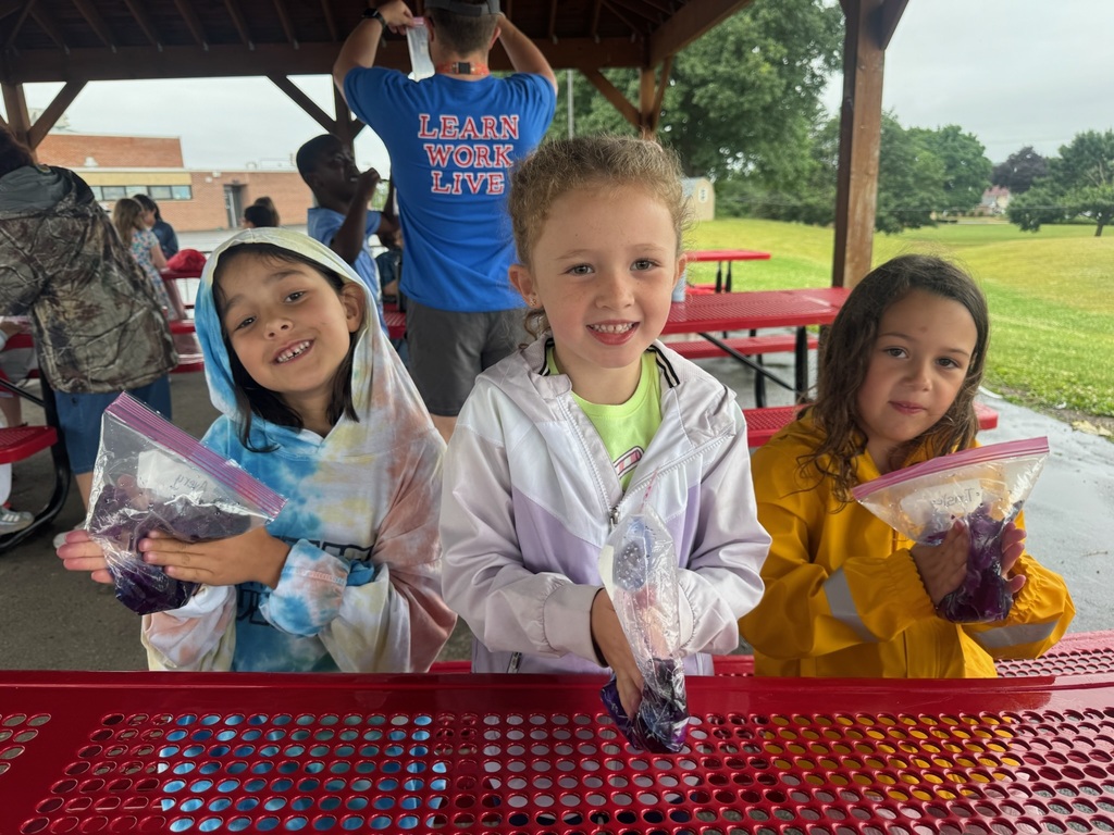 students in coats with gallon size bags doing science project