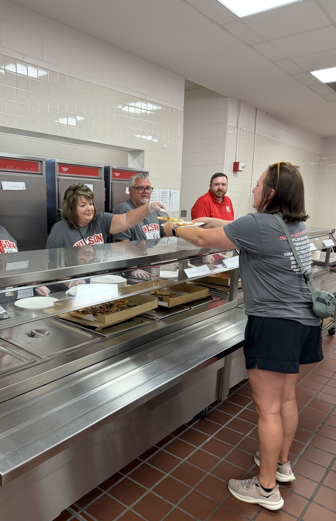 staff members serving pizza for lunch