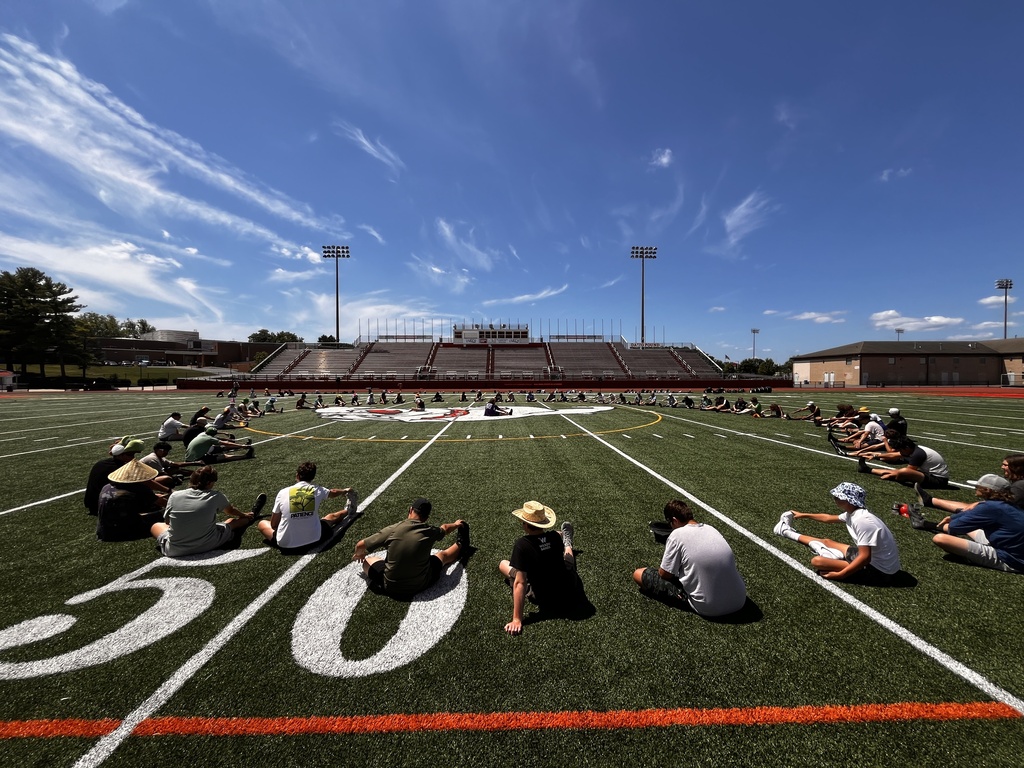 students sitting in circle on the field