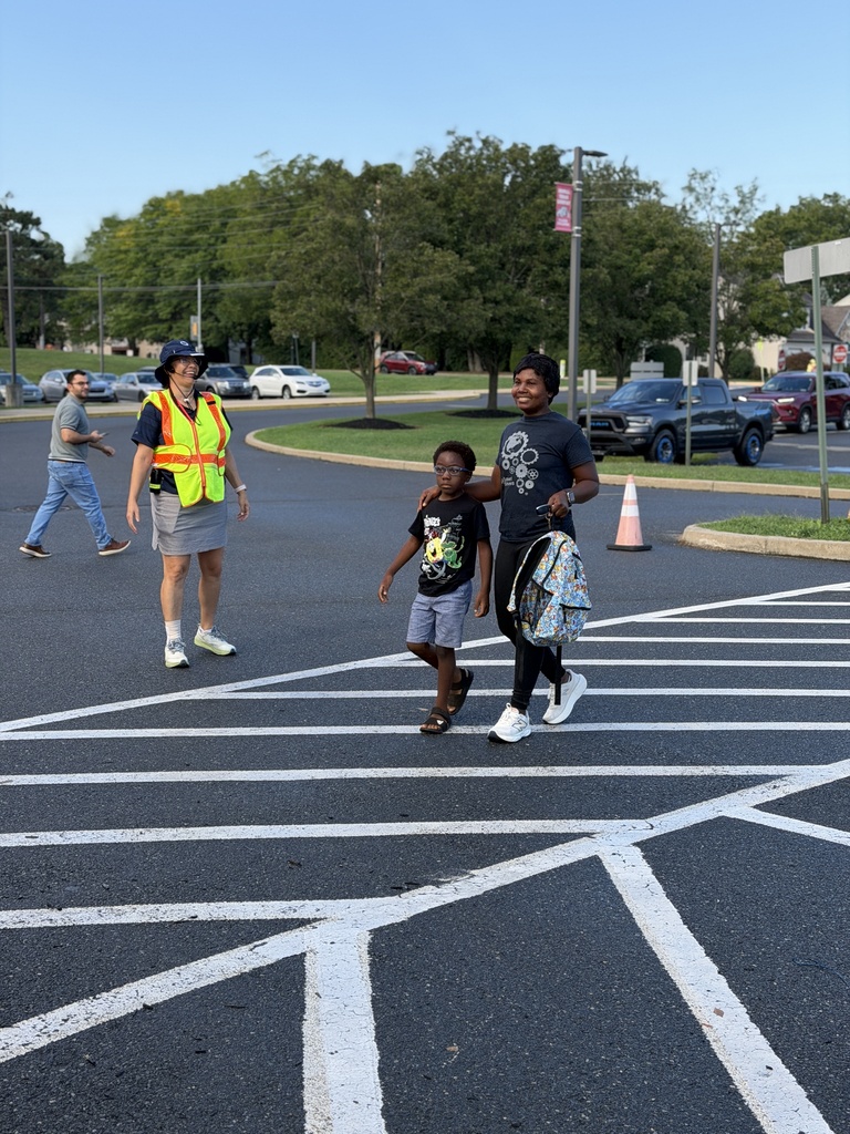 mom and son walking into school at crosswalk
