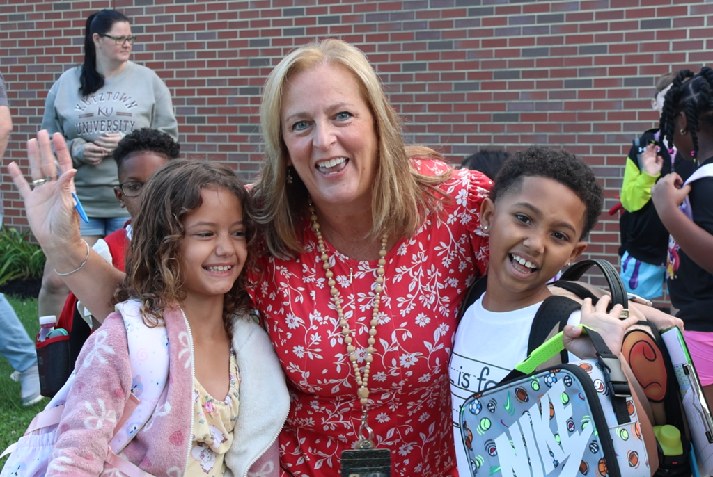 two students smiling with teacher