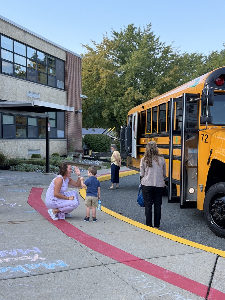 student getting off the bus giving teacher a high five