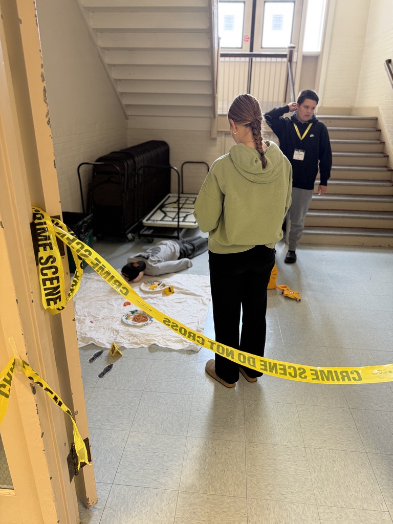 caution tape with fake crime scene in the background