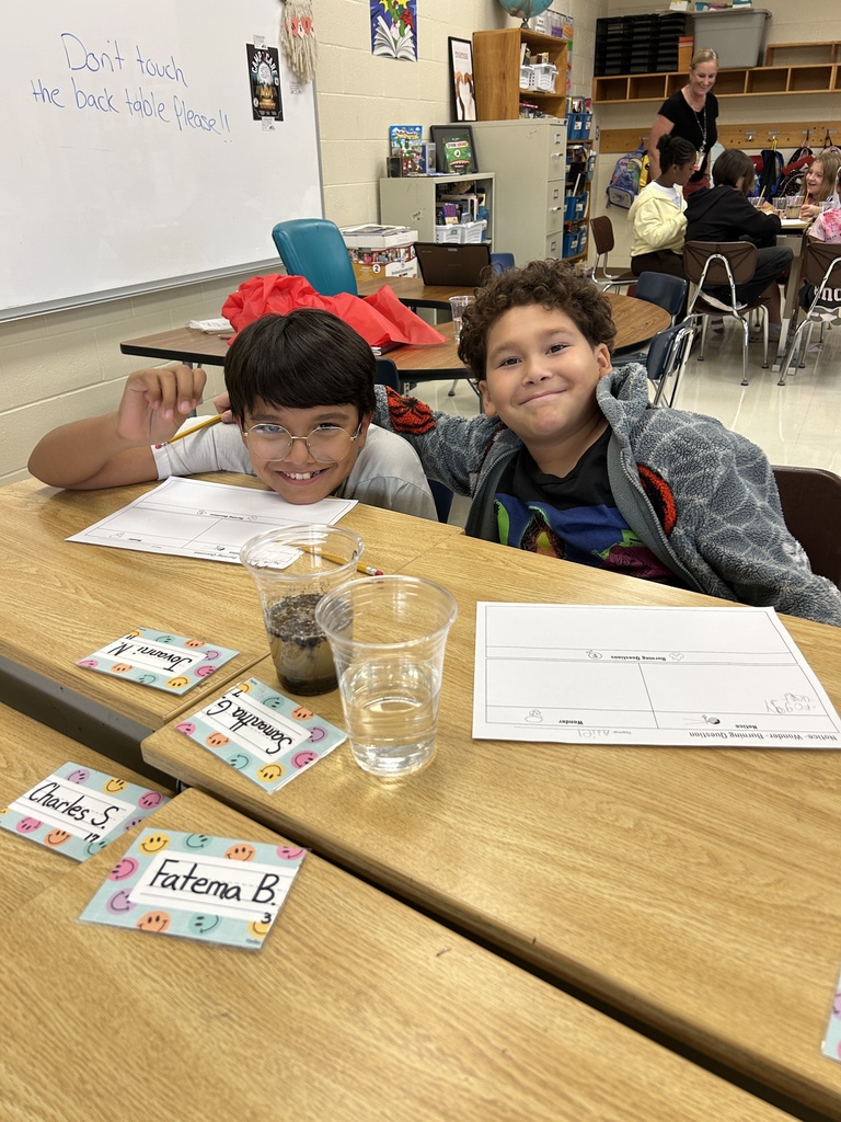 two boys smiling at camera while investigating water