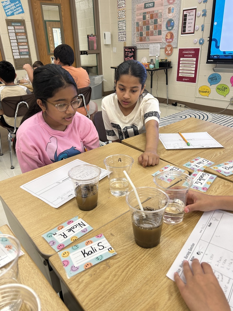 two girls investigating water in cups