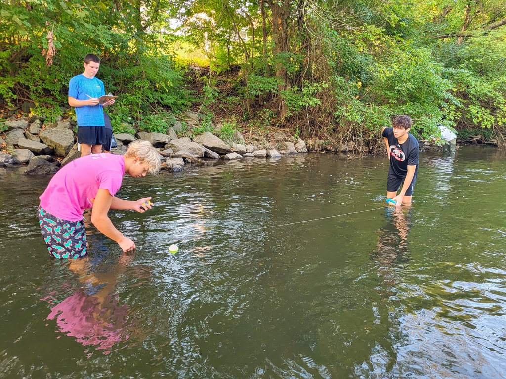 students in the creek with a line 