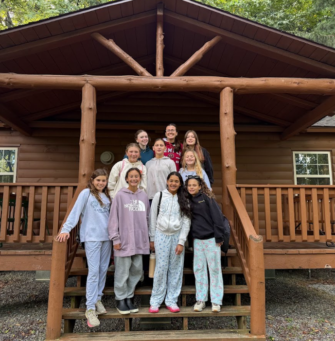 students standing in front of cabin