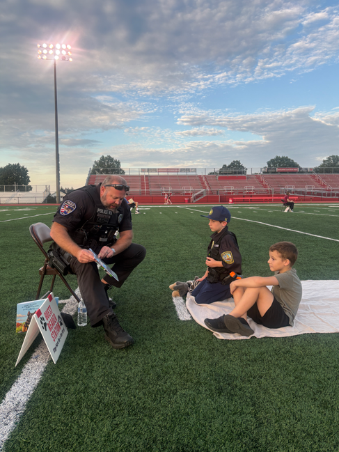 students reading a book with police officer