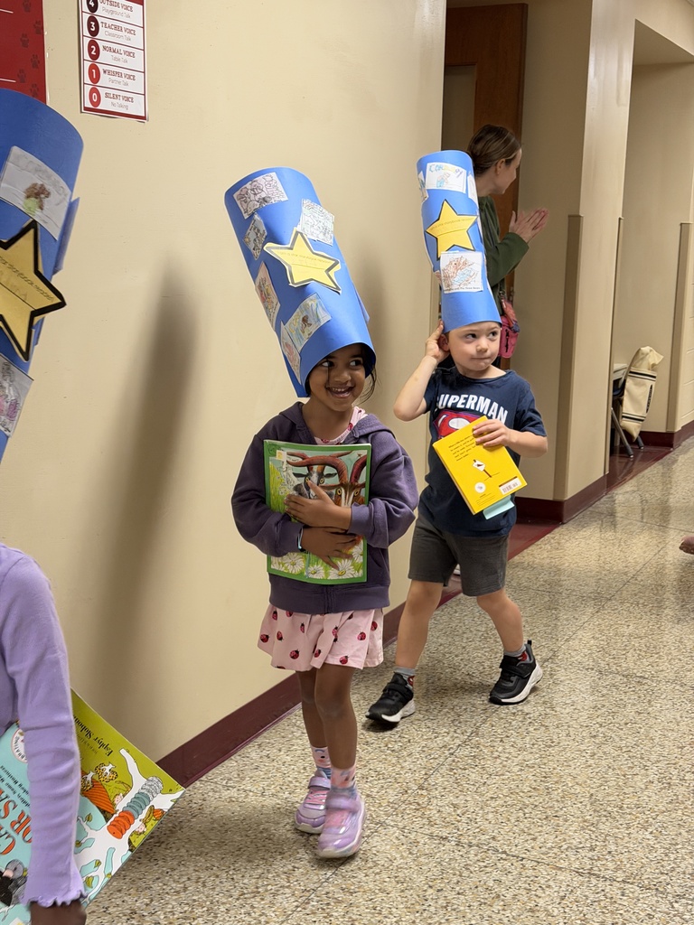 students parading hallway with reader caps on