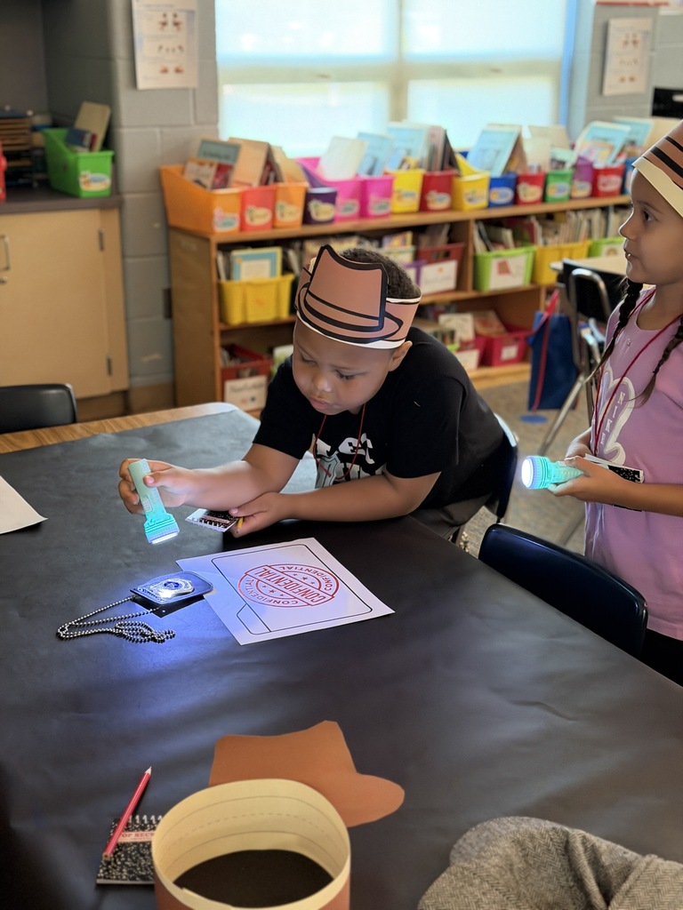 student shining flashlight ontop badge