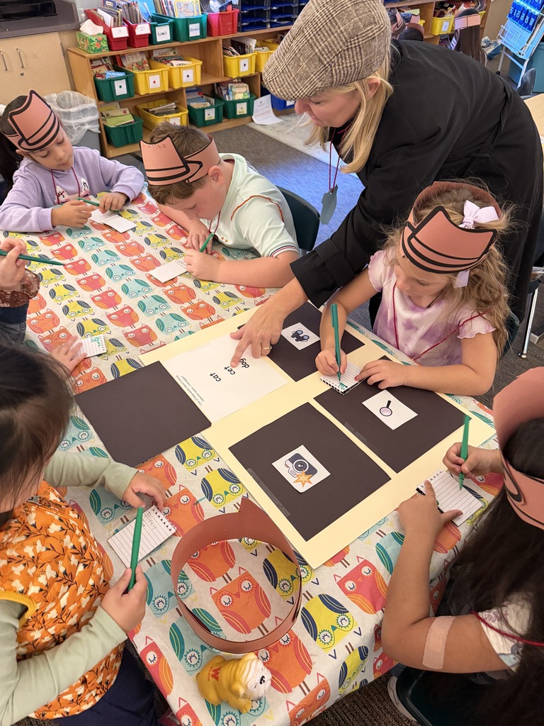 teacher working with students pointing at detective words