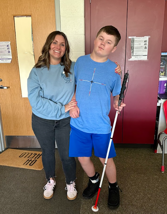 student with cane next to teacher