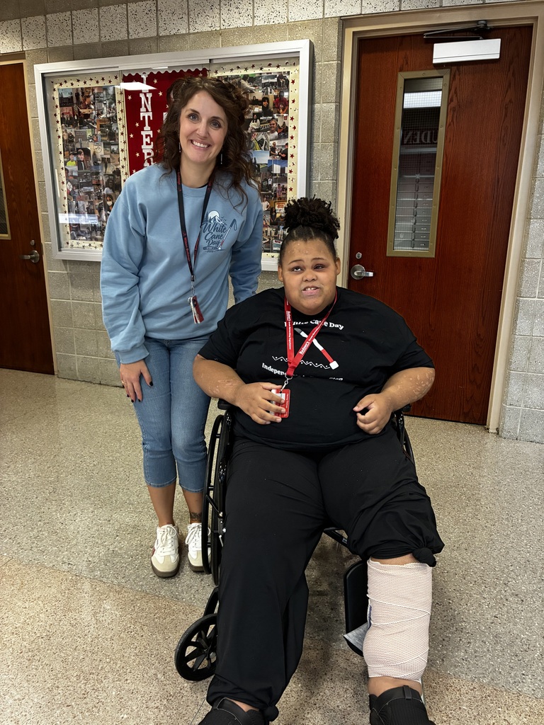 student in wheelchair with white cane day shirt on next to teachwer